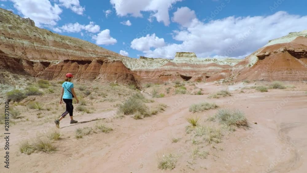 Young woman walking and admiring the view of Toadstool Hoodoos in Utah, USA. Travel and adventure concept. Young woman walking and admiring the view of Toadstool Hoodoos in Utah, USA. Travel and adventure concept.