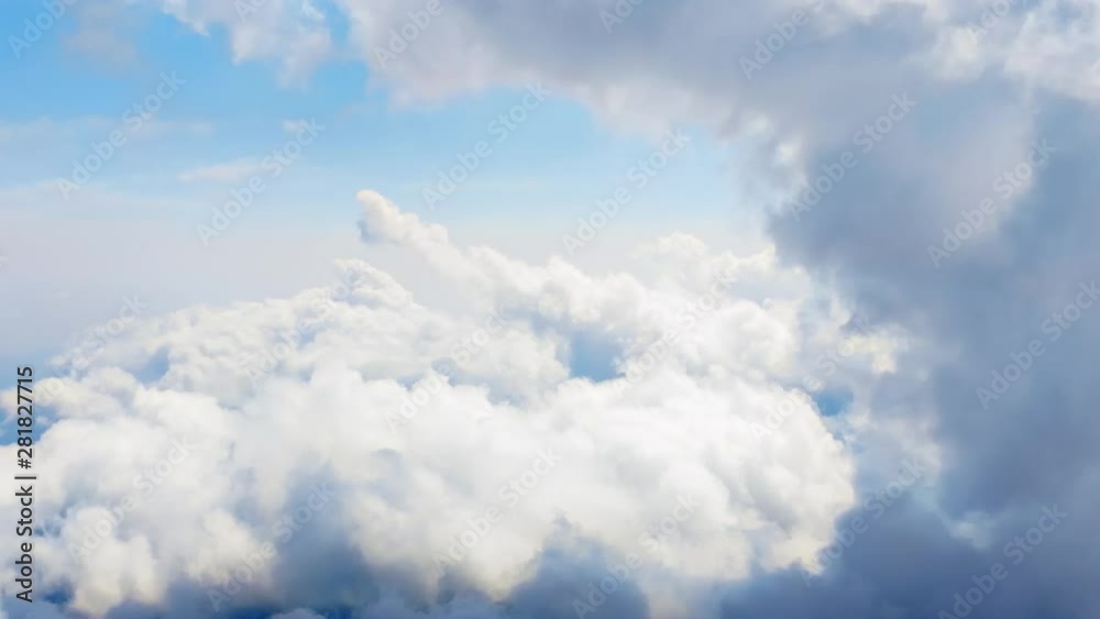 Flying through heavenly beautiful cloudscape. Picturesque timelapse of white fluffy clouds moving softly on the clear blue sky in pure sunshine. Direct view from the cockpit.