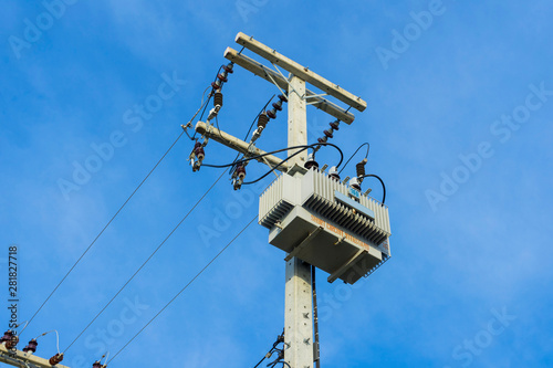 Electric distribution transformer pole and blue sky.