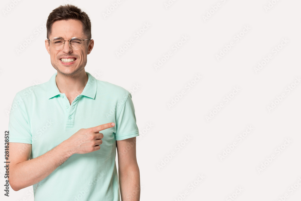 Man pointing aside at copyspace feels embarrassing and shameful Man pointing aside at copyspace feels embarrassing and shameful