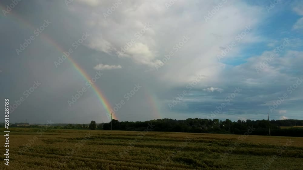 Rainbow Above Wheat Field. Flight Backward Ripe Crop Field After Rain and Colorfull Rainbow in Background Rural Countryside. Areal Dron Shoot. Rainbow Above Wheat Field. Flight Backward Ripe Crop Field After Rain and Colorfull Rainbow in Background Rural Countryside. Areal Dron Shoot.