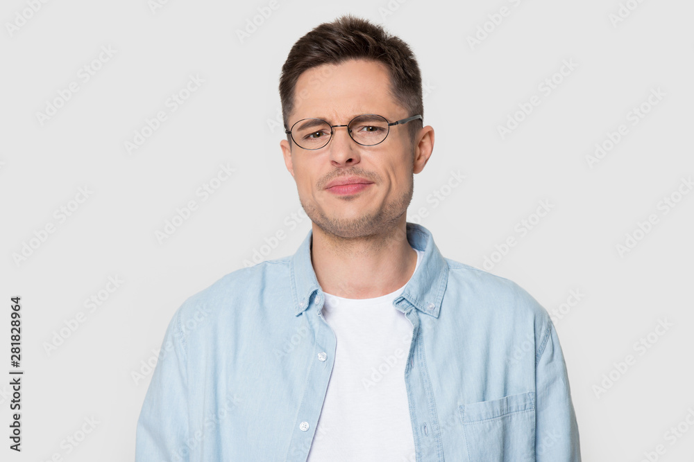 Headshot portrait dissatisfied frowning guy posing over studio background Headshot portrait dissatisfied frowning guy posing over studio background