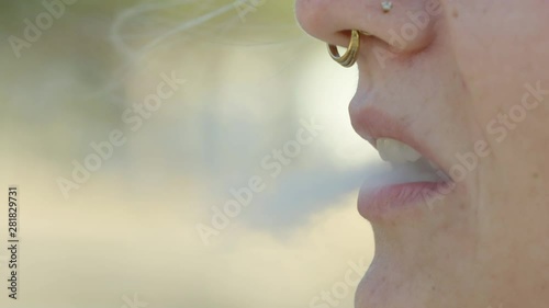 Closeup of a Caucasian woman taking a drag from a vape, 60 fps photo