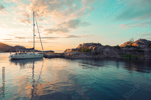 Sailing boat on the island over sunset colourful sky with reflection in the water in the Island summertime, Sweden