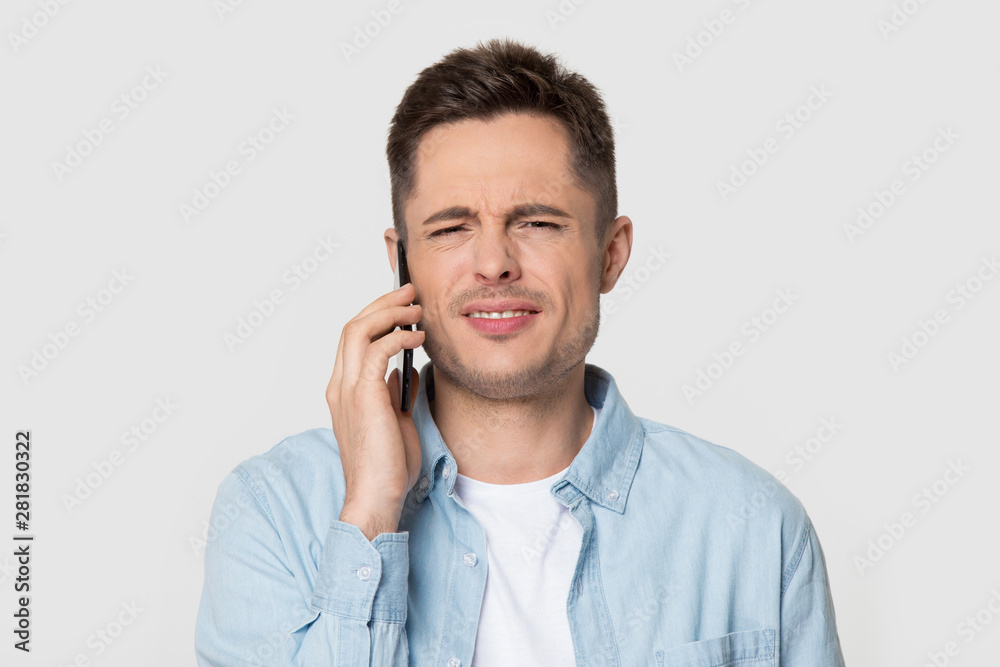 Headshot studio portrait annoyed dissatisfied guy talking on mobile phone Headshot studio portrait annoyed dissatisfied guy talking on mobile phone