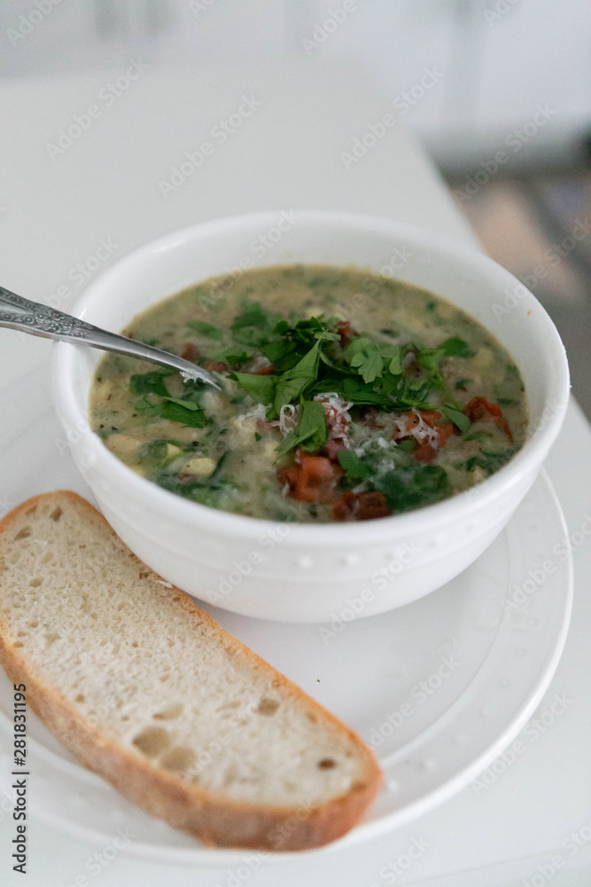 Zuppa Toscana Soup on Table with Bread, White Background