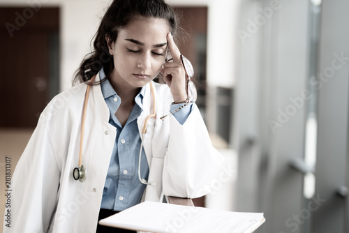 Obraz na plátně Eine müde und überarbeitete junge Ärztin im Krankenhaus