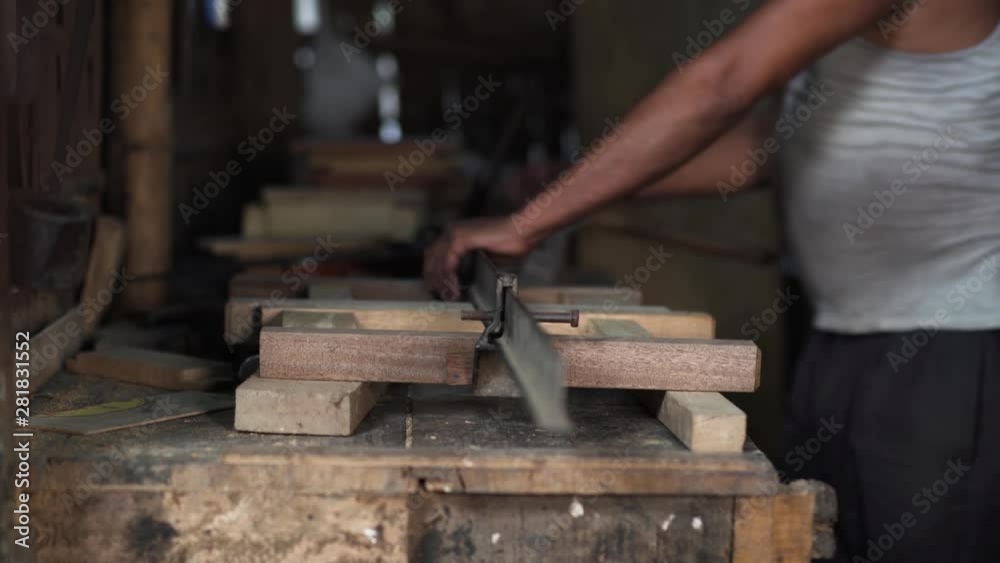 Side view of a carpenter building a wooden structure Side view of a carpenter building a wooden structure