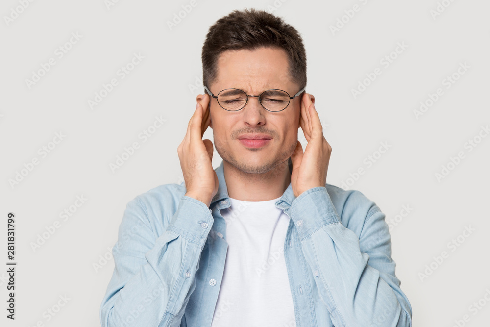 Head shot portrait stressed man touching temples suffers from headache