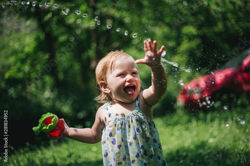 Baby girl playing water in an open space