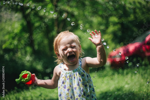 Baby girl playing water in an open space