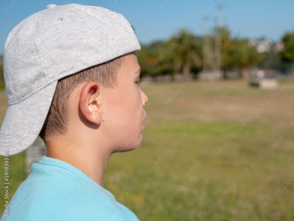 lonenly young boy wearing a cap and looking sad 
