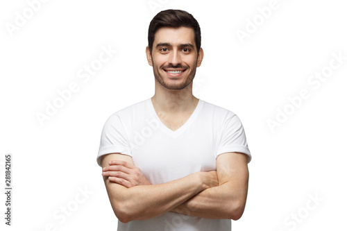 Smiling handsome man in casual t-shirt standing with crossed arms, isolated on white background © Damir Khabirov