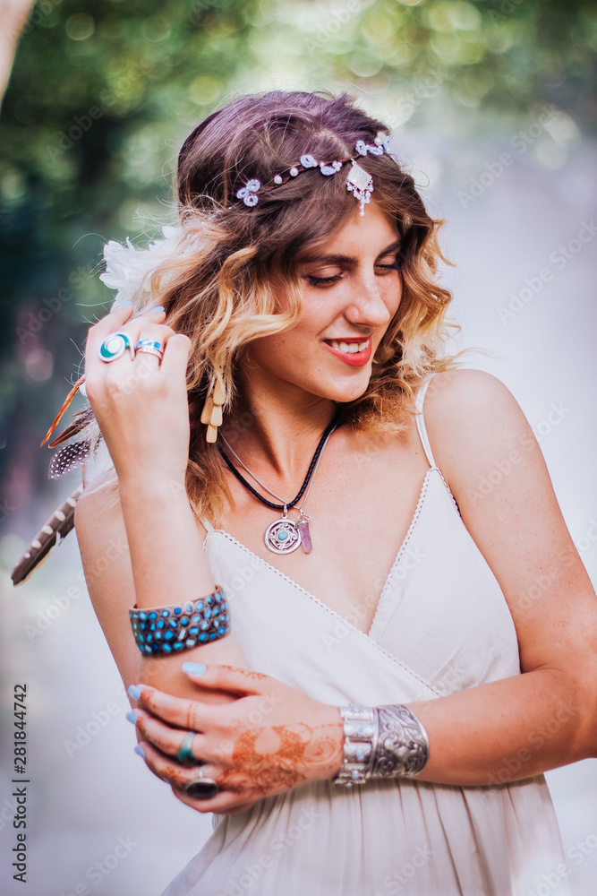 Bohemian hippie girl in white dress. Woman with boho style jewelry. Colored smoke on background.Coachella Bohemian Look. Spirit of freedom. Bohemian hippie girl in white dress. Woman with boho style jewelry. Colored smoke on background.Coachella Bohemian Look. Spirit of freedom.