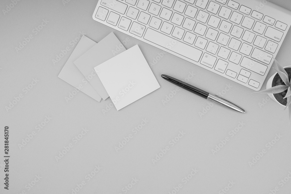Flat lay, top view office table desk. Workspace with pen, sticky notes, decoration vase and keyboard on Black and White. Business Finance, Education and Copy Space concept Flat lay, top view office table desk. Workspace with pen, sticky notes, decoration vase and keyboard on Black and White. Business Finance, Education and Copy Space concept