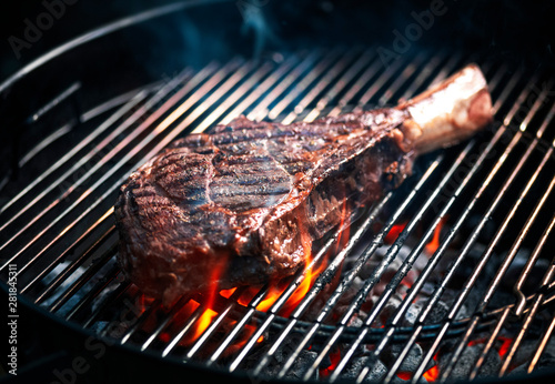 Angus beef tomahawk steak being grilled on a BBQ