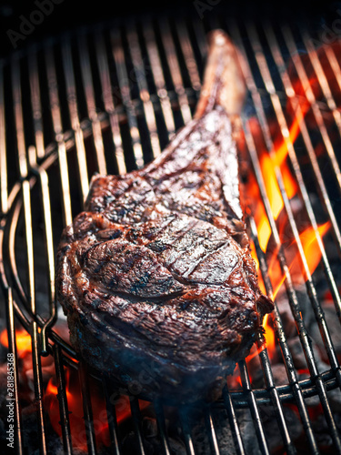 Angus beef tomahawk steak being grilled on a BBQ