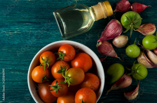 Tomatoes on the background. Tomatoes, garlic on a wooden surface. View from above. Fresh vegetables. copy space.