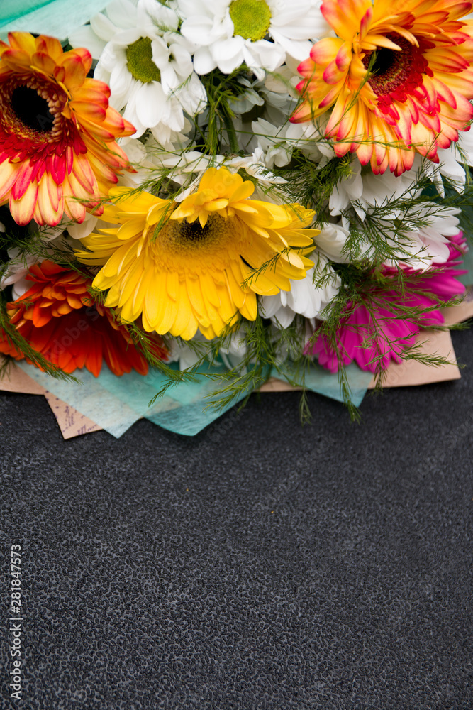 bouquet of gerberas on a black background place copy yellow green pink white orange top view