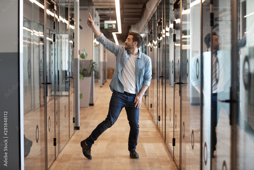 Funny excited young businessman winner dancing alone in office hallway