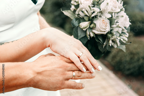 wedding rings on the hands of the bride and groom.