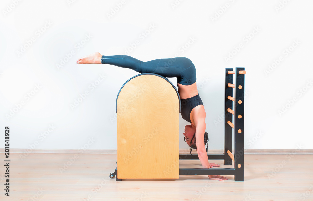 Fotografia do Stock: Young Girl doing exercises on ladder barrel - Pilates