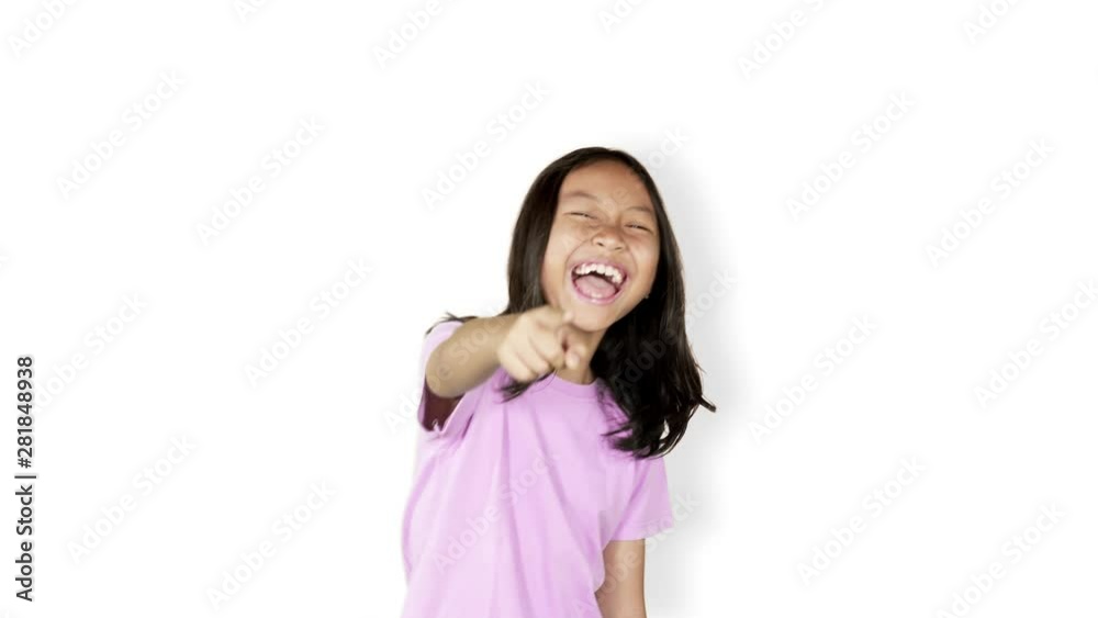 Female elementary school student looks mocking someone while laughing and pointing at the camera in the studio, isolated on white background. Shot in 4k resolution Female elementary school student looks mocking someone while laughing and pointing at the camera in the studio, isolated on white background. Shot in 4k resolution