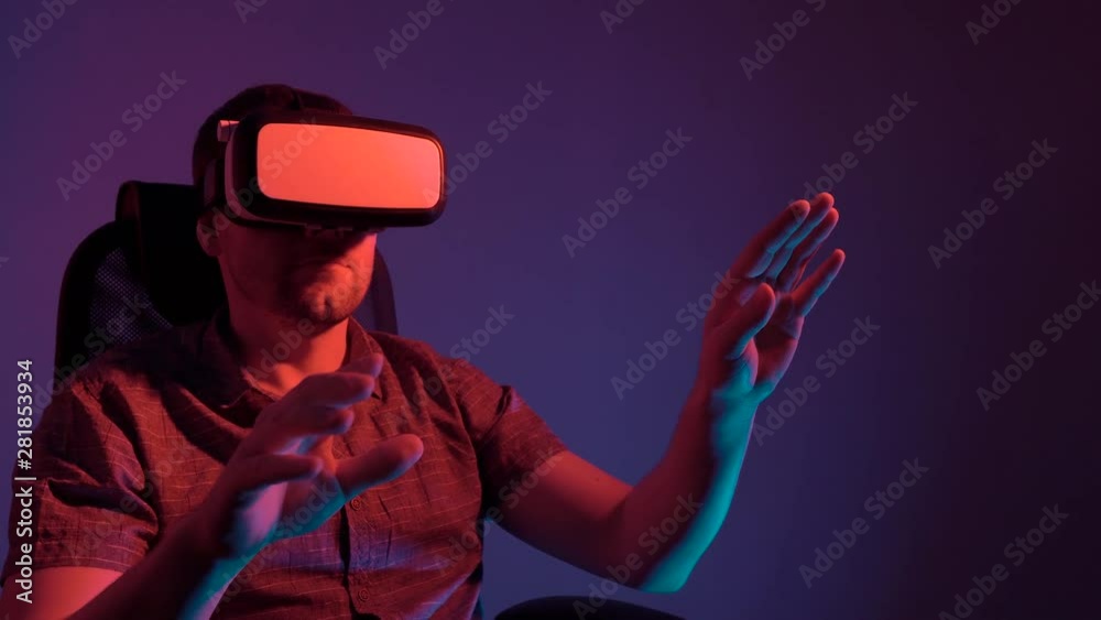 A man wearing glasses of virtual reality sits on a chair and moves his hands. 4k video A man wearing glasses of virtual reality sits on a chair and moves his hands. 4k video