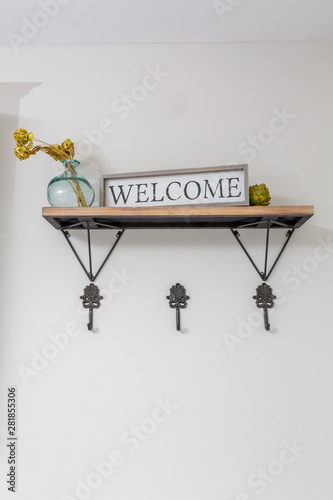 Entryway decor of home, hooks on wall, shelf with modern decor