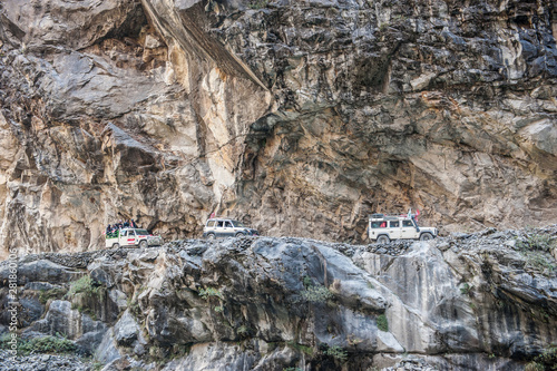 Cars, jeeps and excavator, digger (dredger) on the main road of Annapurna circuit. Himalayas, Nepal.
