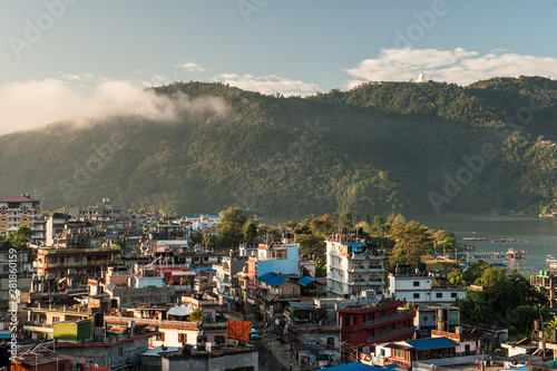 Landscape with Pokhara rooftops on sunrise with Annapurna South, Hiunchuli and Machapuchare Fishtail Peaks in background. Himalaya Mountains, Nepal.