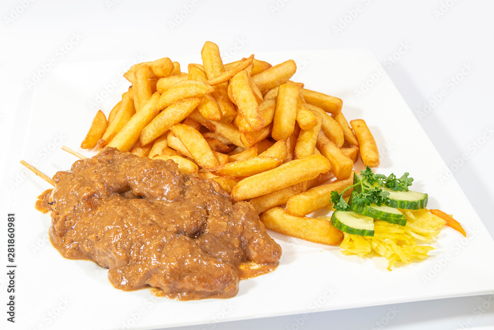Chicken skewers served with a tasty peanut sauce and French fries Chicken skewers served with a tasty peanut sauce and French fries