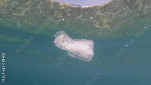 plastic bag and bottle in sea water. underwater footage of pollued water. photo