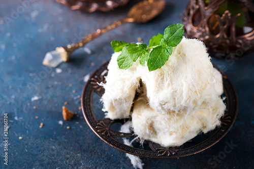 Traditional Turkish cotton candy Pismaniye in vintage plate with tea on stone background photo