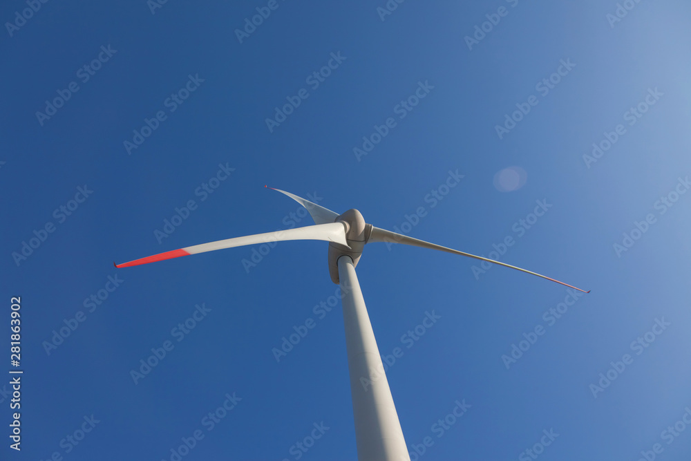 wind turbine with sun flare blue sky background view from below wind turbine with sun flare blue sky background view from below
