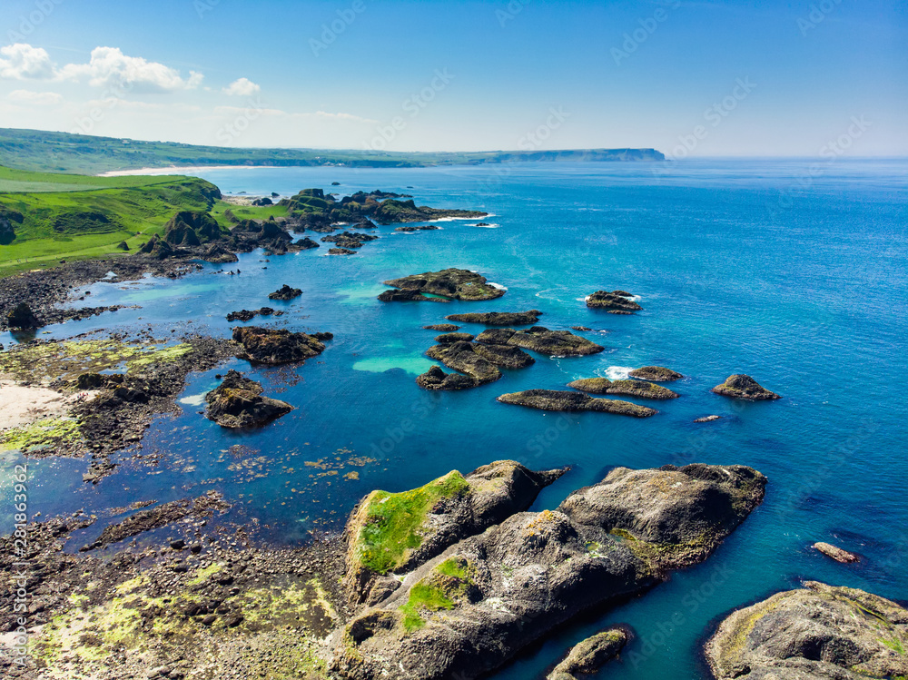 Vivid emerald-green water at Ballintoy harbour along the Causeway Coast in County Antrim. Rugged coast of Northern Ireland.