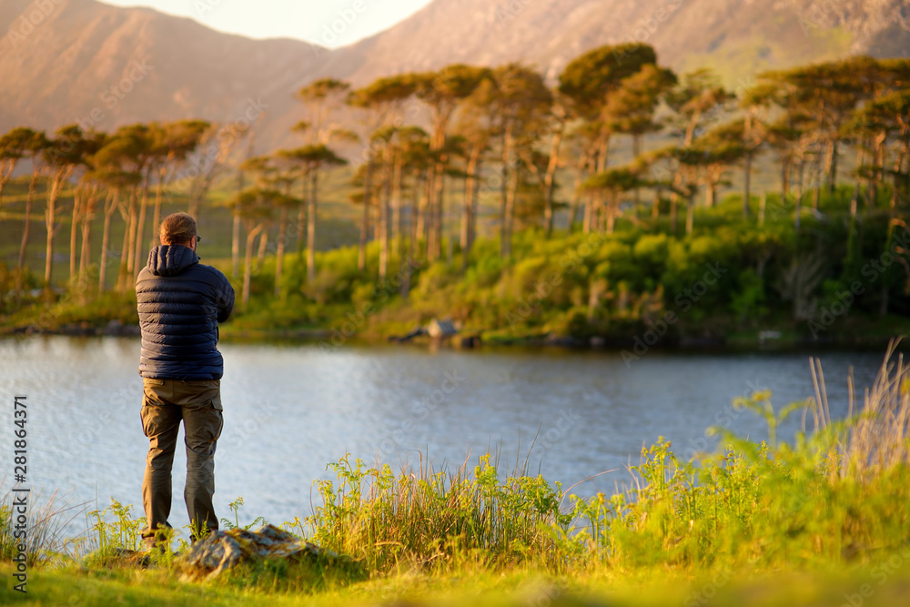 Tourist admiring the view of Twelve Pines Island, Connemara, County Galway, Ireland Tourist admiring the view of Twelve Pines Island, Connemara, County Galway, Ireland