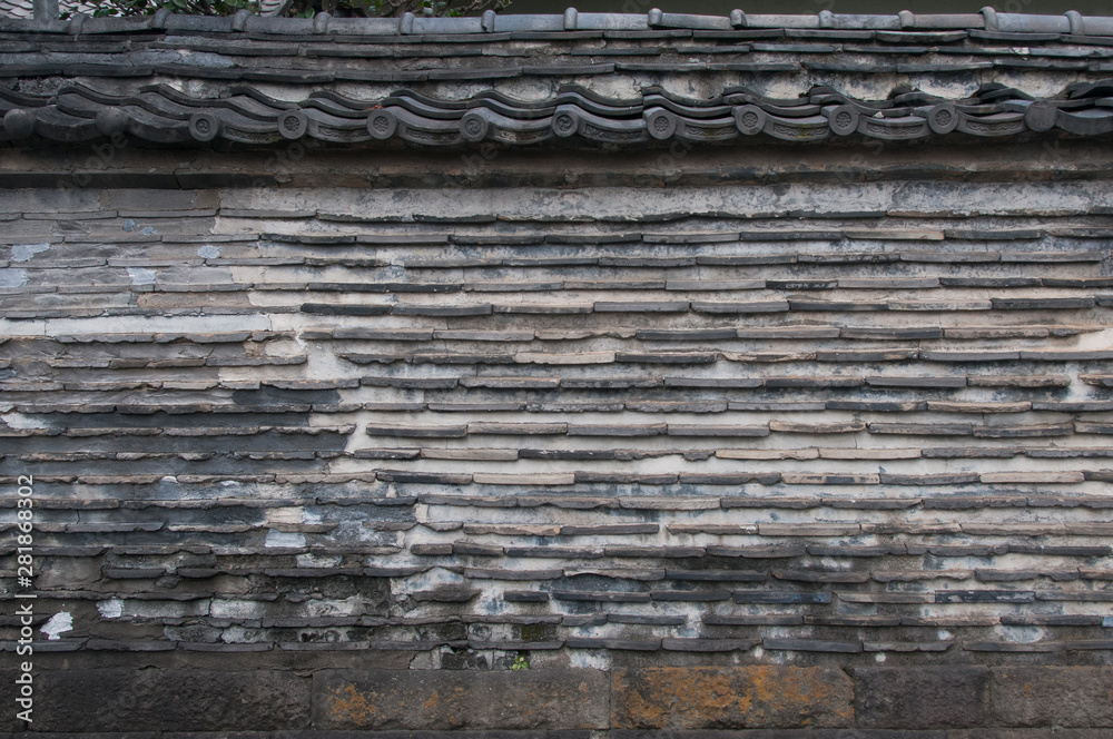A roofed wall made of mud and tiles surround part of a temple in Tokyo’s nostalgic Yanaka district, Japan. 