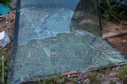 broken triplex glass lies on the ground photo