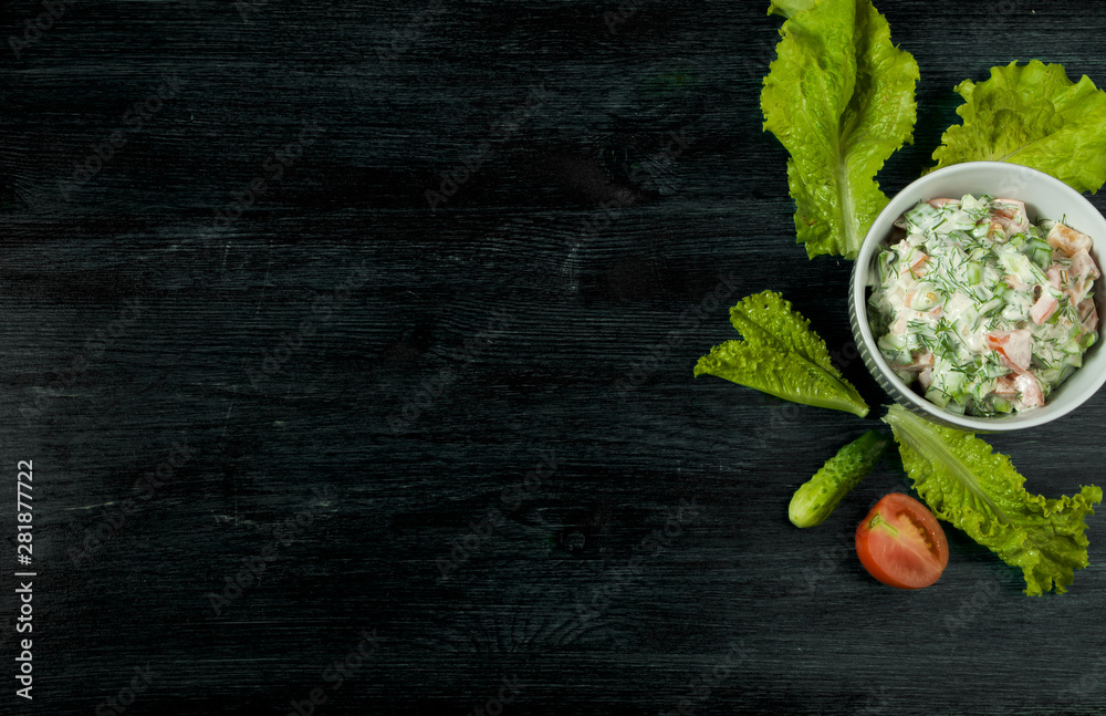 Salad with vegetables. View from above. Fresh salad in a plate on a dark background. Garlic, tomato, cucumber, dill and onion in a dish of dark surface. Copy space. Salad with vegetables. View from above. Fresh salad in a plate on a dark background. Garlic, tomato, cucumber, dill and onion in a dish of dark surface. Copy space.