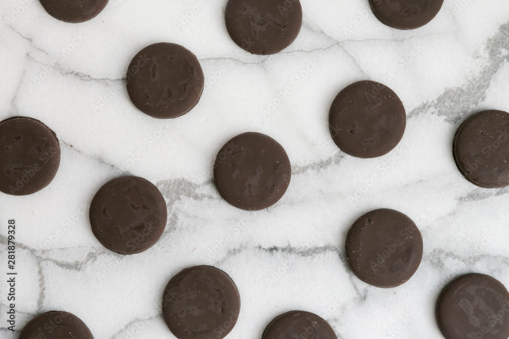 Group of thin mints cookies on white marble background, chocolate mint thin round cookies, top view Group of thin mints cookies on white marble background, chocolate mint thin round cookies, top view