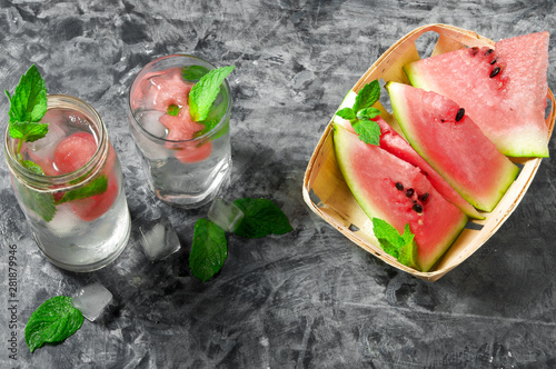 Watermelon cocktail. Watermelon cocktail with mint and slices of watermelon on a gray concrete surface. View from above. Copy space.