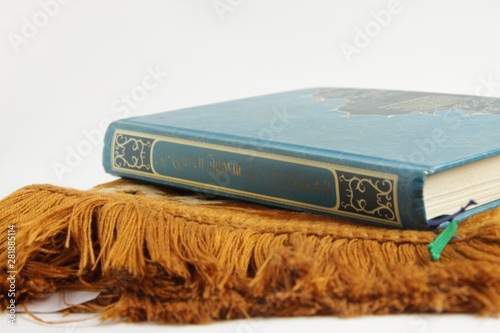 Holy Quran on a brown prayer rug photo