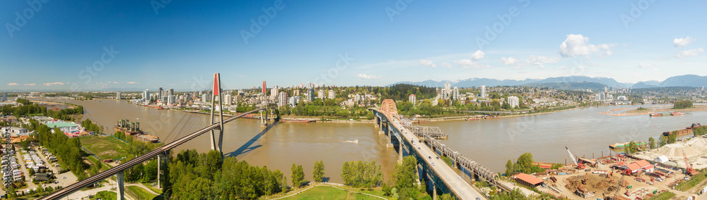 Aerial panoramic view of Pattullo Bridge and Skytrain Bridge over the Fraser River. Taken in Surrey, Greater Vancouver, British Columbia, Canada.