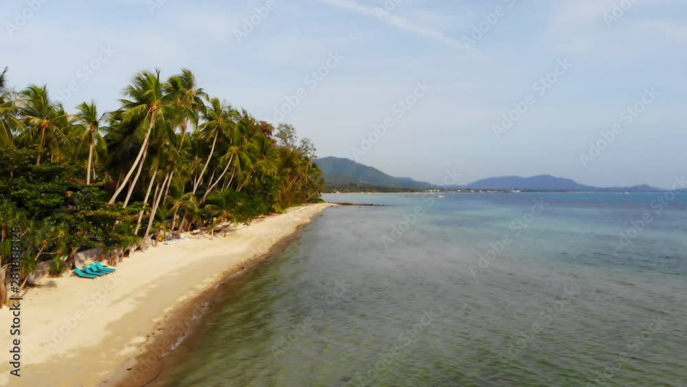 Aerial view of a deserted remote tropical beach with lounge chairs Aerial view of a deserted remote tropical beach with lounge chairs
