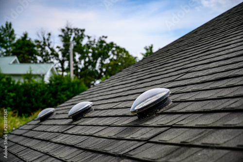 Photography Dome shaped solar tube skylight on asphalt shingle roof