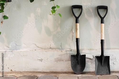 Garden tools shovel on wall background.