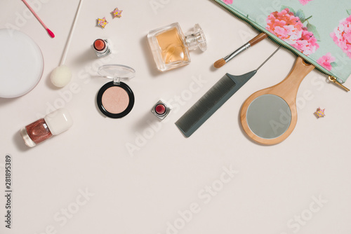 Make up bag with cosmetics on color background