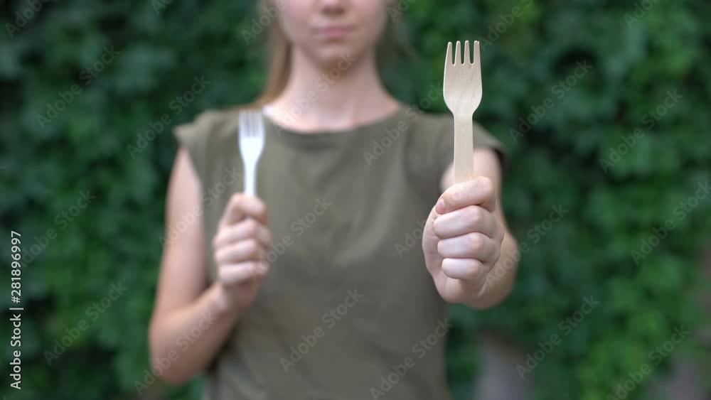 Lady showing wooden fork to cam preferring natural materials to plastic, ecology