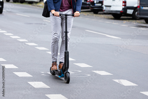 Businessman Riding An Electric Scooter On Road